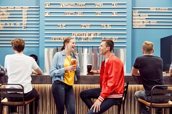 Couple standing at the bar enjoying a beer at the High River Brewing Company.