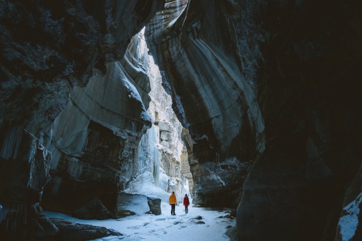 Two people standing in an ice cave