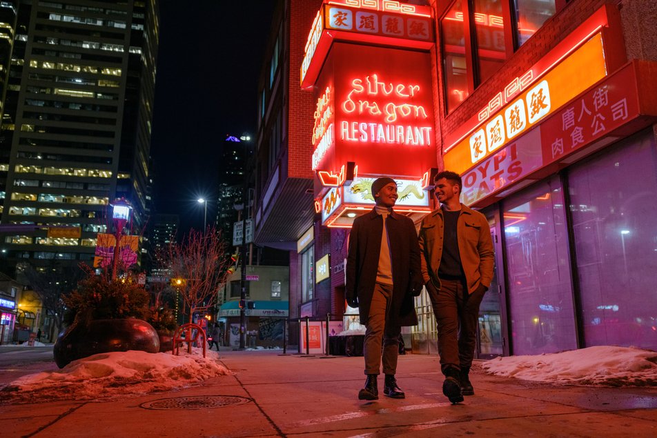 Two men walk down the street at night in front of the Silver Dragon restaurant in Calgary’s Chinatown area.