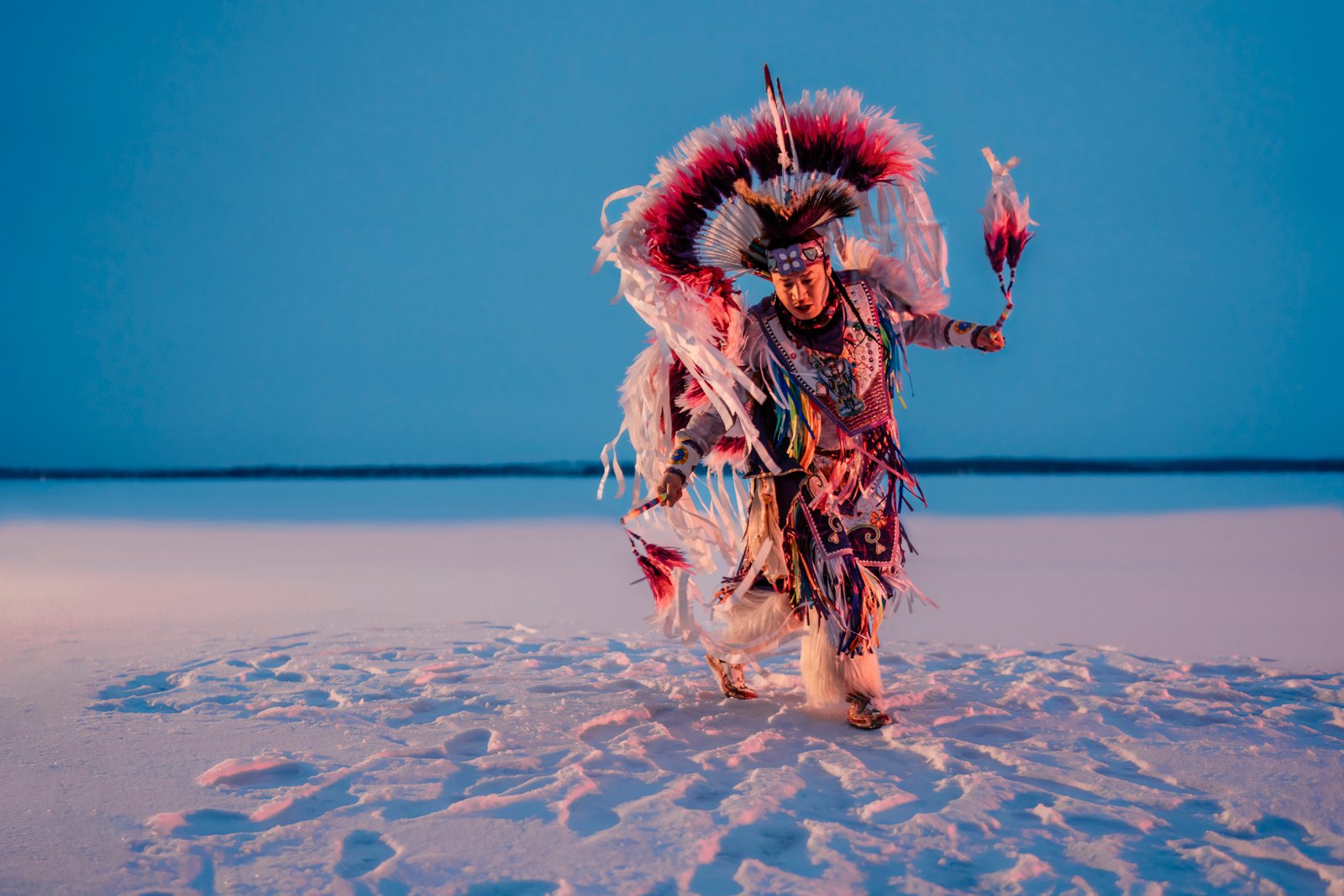 Indigenous dancer focused on their movement on the beach.