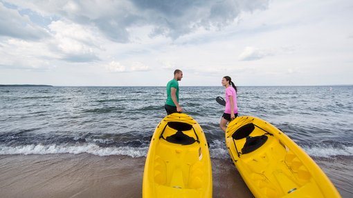 Couple taking kayaks out on Kinosoo Beach - Cold Lake