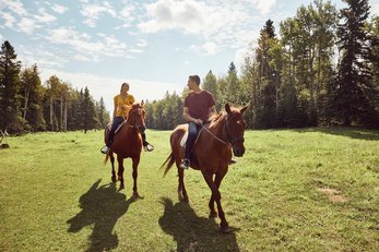 Couple horseback riding at Painted Warriors Ranch