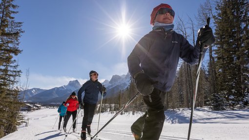 A family cross country skiing on one of the groomed trails at the Canmore Nordic Centre.