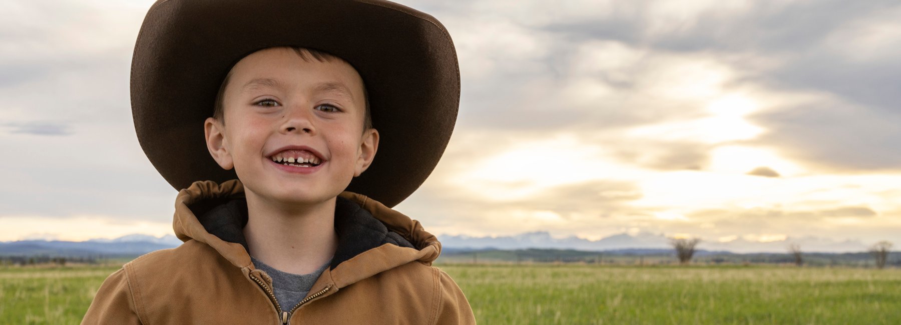 Young boy standing in a field in Alberta.