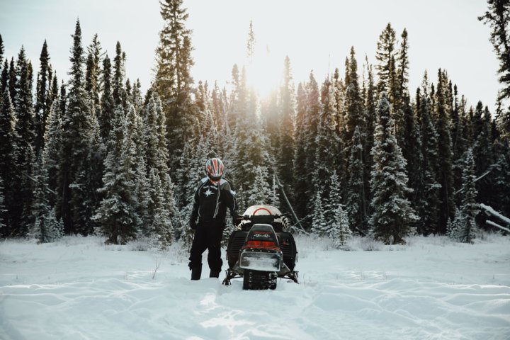 Man standing beside his snowmobile