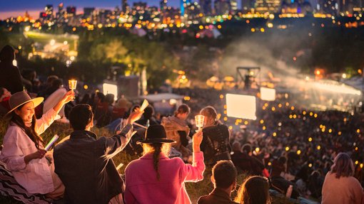 People enjoying performances at night at the Edmonton Folk Festival.