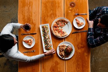 Two people enjoying food and drinks at the Iron Goat Restaurant in Canmore.