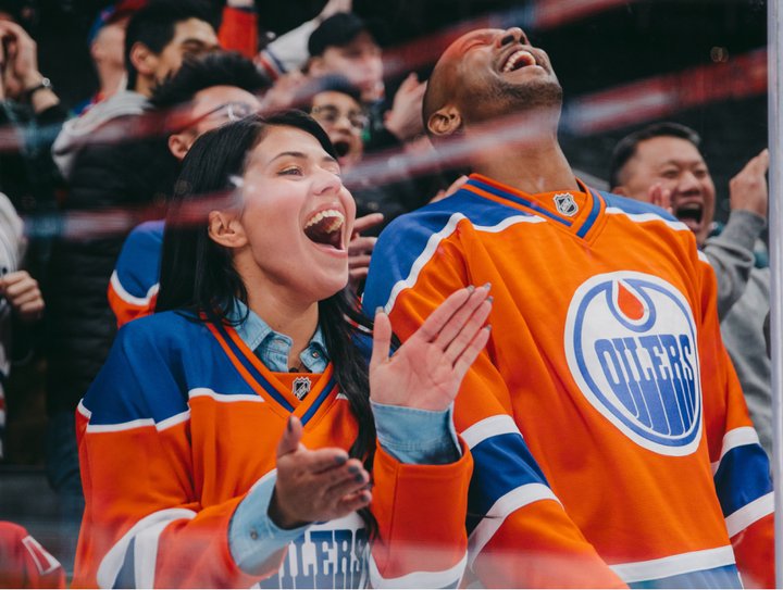 Edmonton Oilers hockey fans cheering on their hockey team from the arena stands.