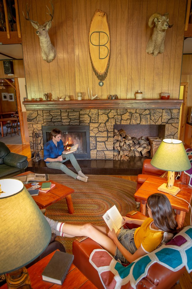 couple reading inside retro living room at Black Cat Guest Ranch jasper national park