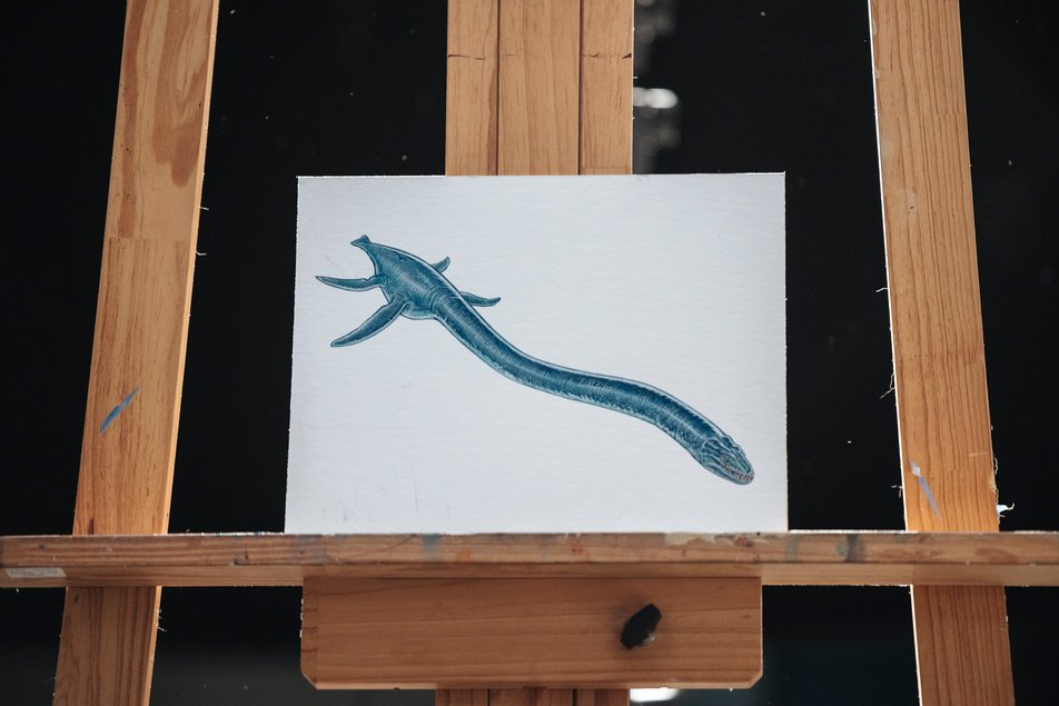 A painting of an Albertonectes sits on a wooden easel.