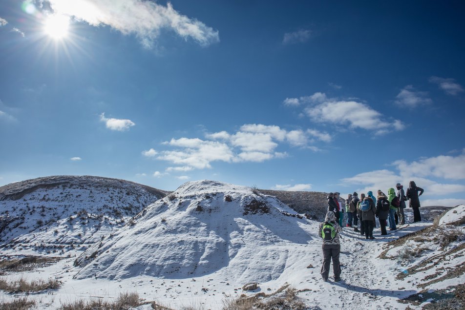 A group of hikers huddle at the top of a trail before continuing their hike at Dinosaur Provincial Park.