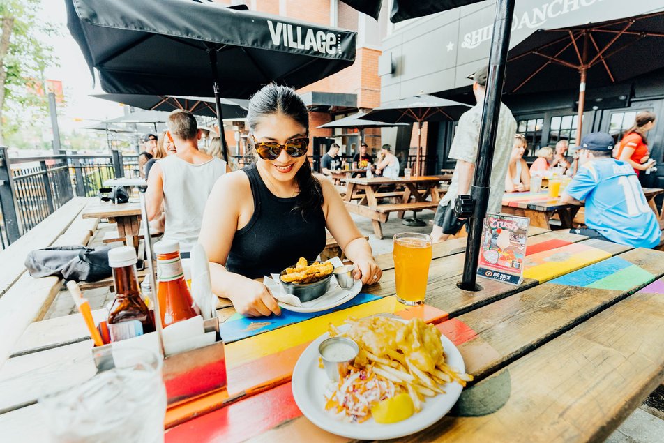 Woman at a picnic table on outdoor patio at the Ship and anchor pub calgary