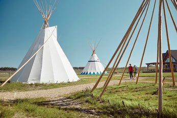 Visitors walking through the tepees at Chiniki Cultural Centre