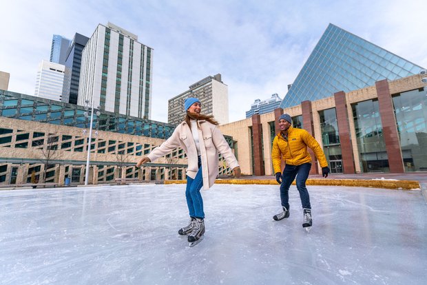 A couple ice skating on the outdoor ice rink at Sir Winston Churchill Square in Edmonton.