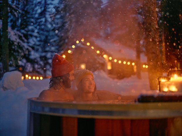 A couple soaking in a hot tub at a lodge in Banff National Park.