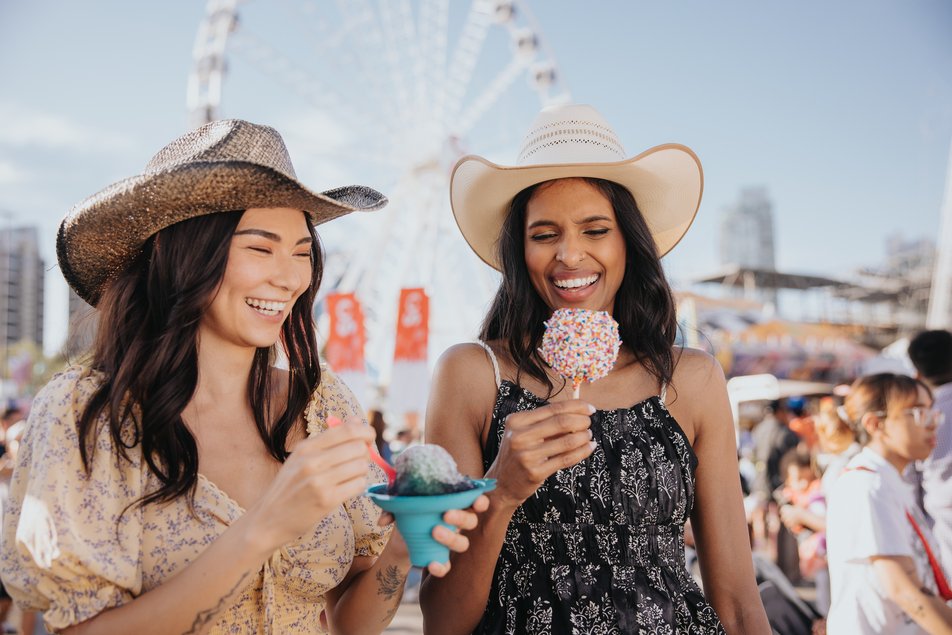 Girls enjoying some midway food and treats at the Calgary Stampede.