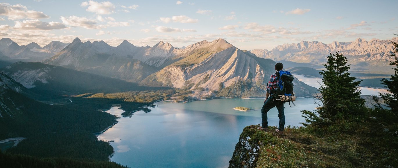 Hiker looking out over a beautiful mountain and lake view