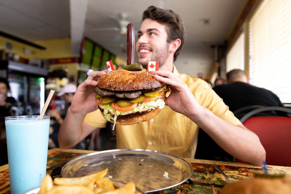 Man eating a burger in a restaurant.