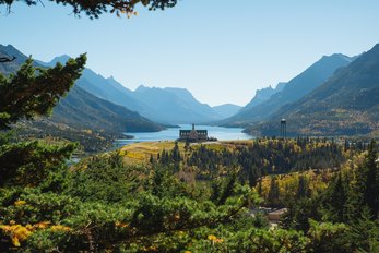 Scenic view of the Prince of Wales Hotel surrounded by forest and mountains in Waterton Lakes National Park