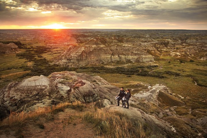 Couple watching the sunset at Dinosaur Provincial Park in the Canadian Badlands, Southern Alberta