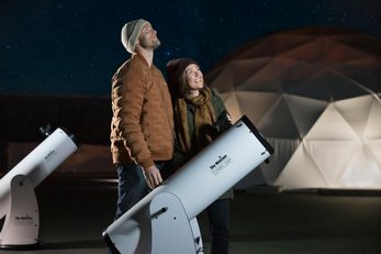 Young couple outside looking skyward at the Jasper Planetarium