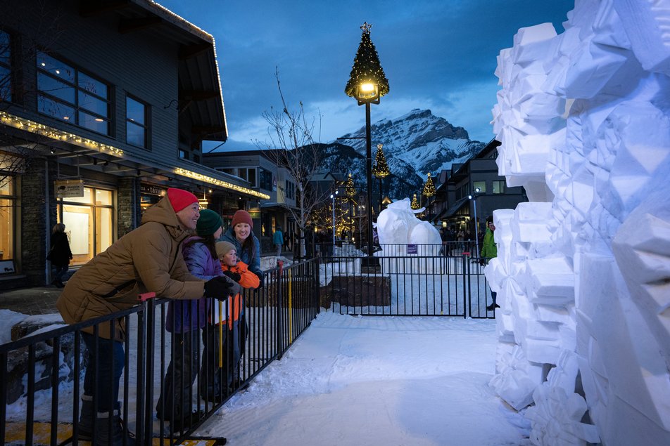 Family admiring snow sculptures at the SnowDays Festival in Banff