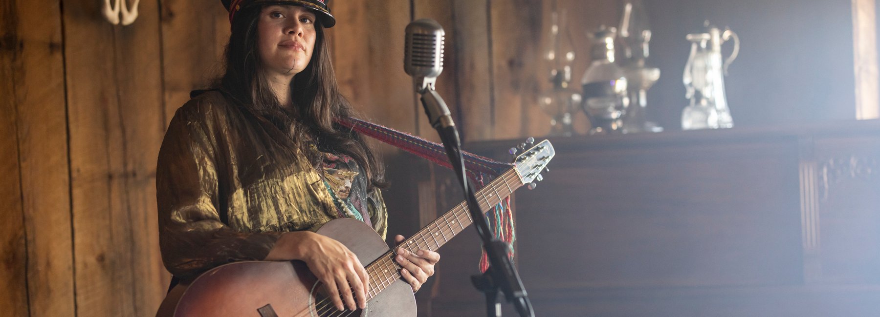 Alberta musician Bebe Buckskin stands with a guitar and microphone