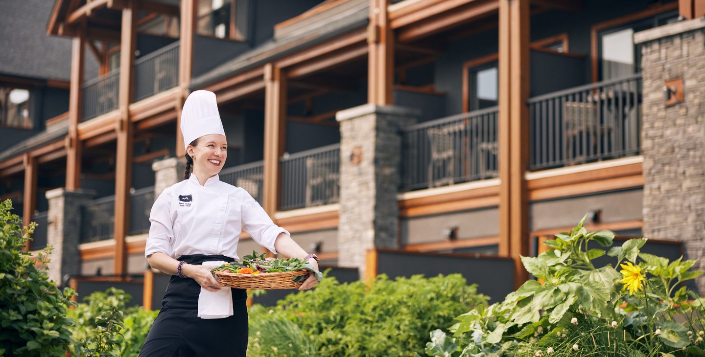 A chef at the Malcolm Hotel in Canmore carries a tray of fresh produce.