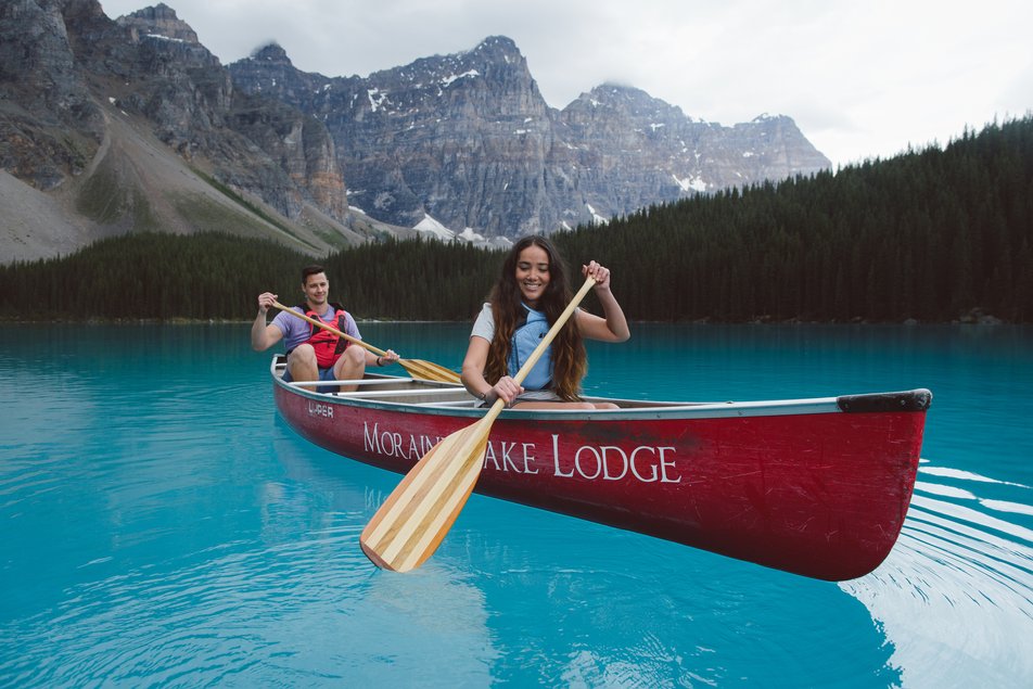 People canoeing with mountains in the background