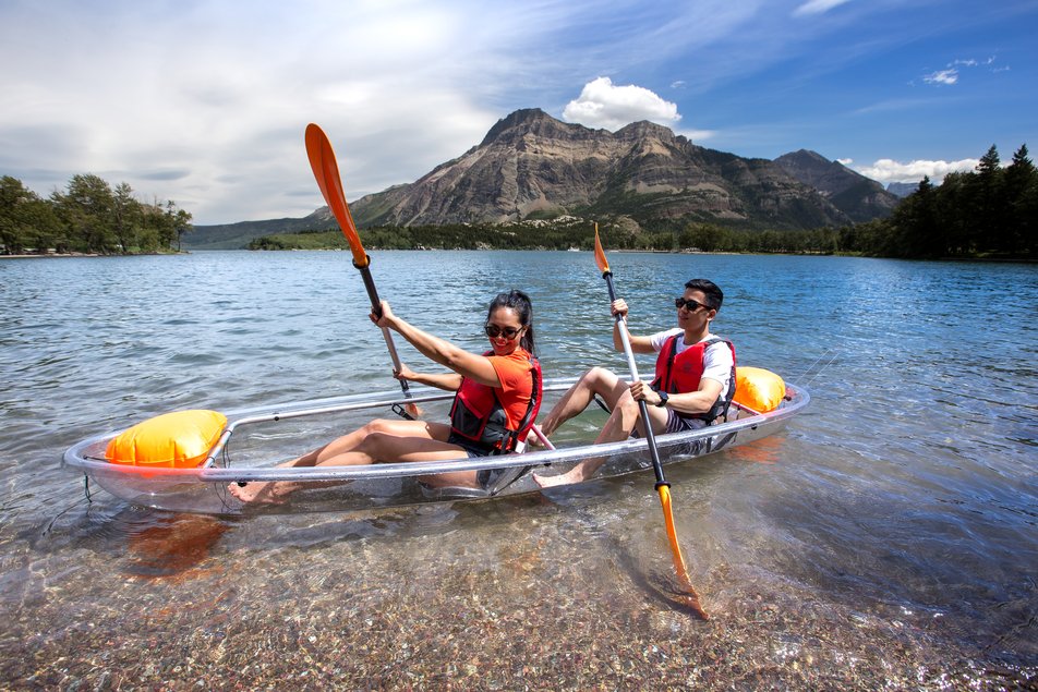 Couple canoeing on a lake with mountains in the background