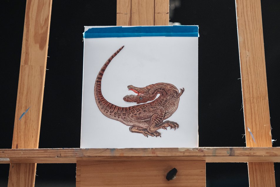 A painting of a Gorgosaurus libratus sits on a wooden easel.