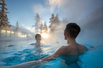 A couple relax and enjoy in the Upper Hot Springs in Banff National Park.