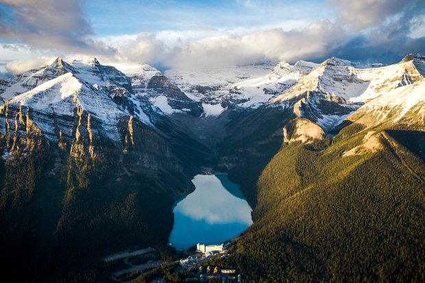 Aerial view of the Fairmont Chateau Lake Louise surrounded by mountains in Banff National Park.