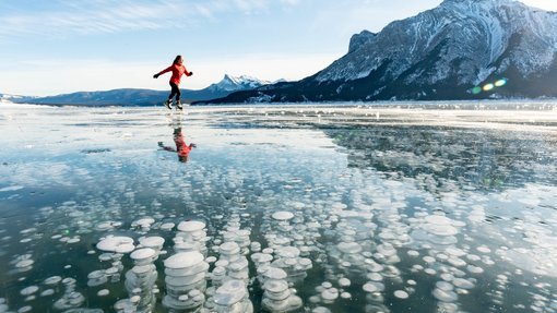 Ice skating on Abraham Lake with bubbles. Central Alberta, Canada.