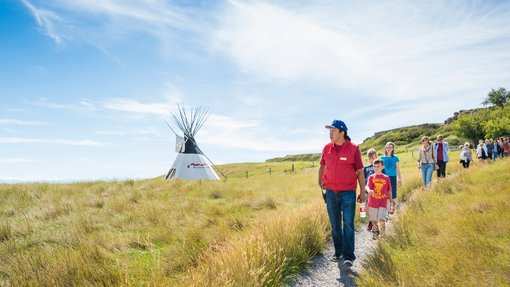 A school group walking the pathways at Head-Smashed-In Buffalo Jump with an Indigenous guide.