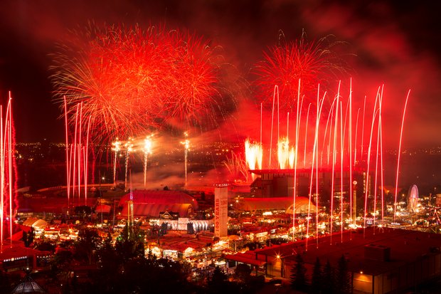 View of the Calgary Stampde Park being lit by red fireworks at night