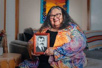 Yvonne Jobin, founder of Moonstone Creation, holds up a framed portrait.