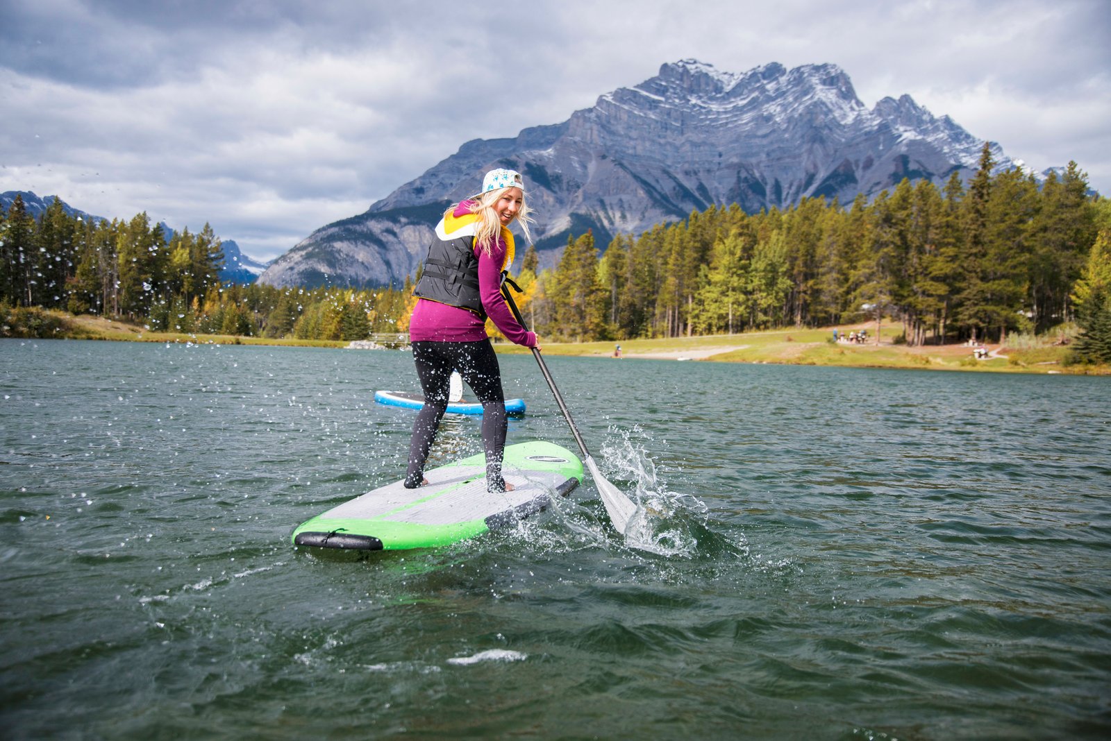 Stand up paddle boarding on Johnson Lake with views of the mountains in Banff National Park.