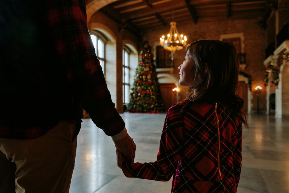 Dad and daughter look at Christmas tree inside Fairmont Banff Springs