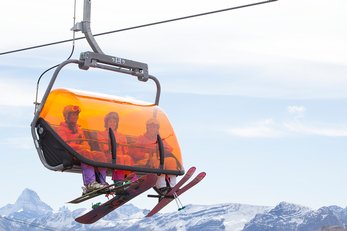 Three skiers ride the heated chairlift at Sunshine Village in Banff National Park.
