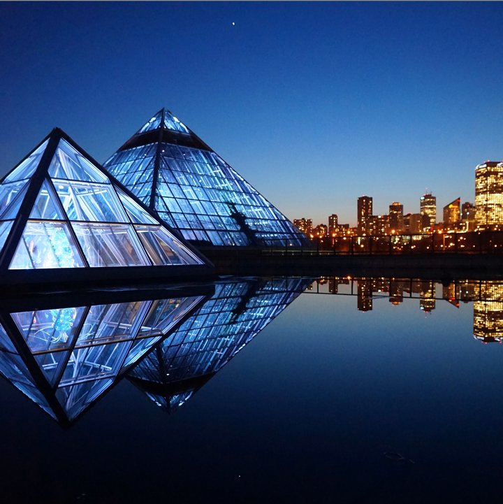 The Muttart Conservatory pyramid buildings and city lights at night in Edmonton.