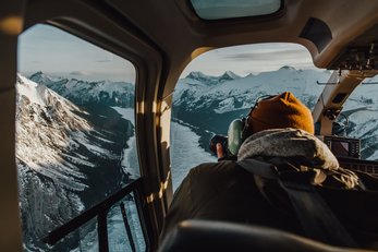 Visitor taking photos over Spray Valley while on a helicopter tour.